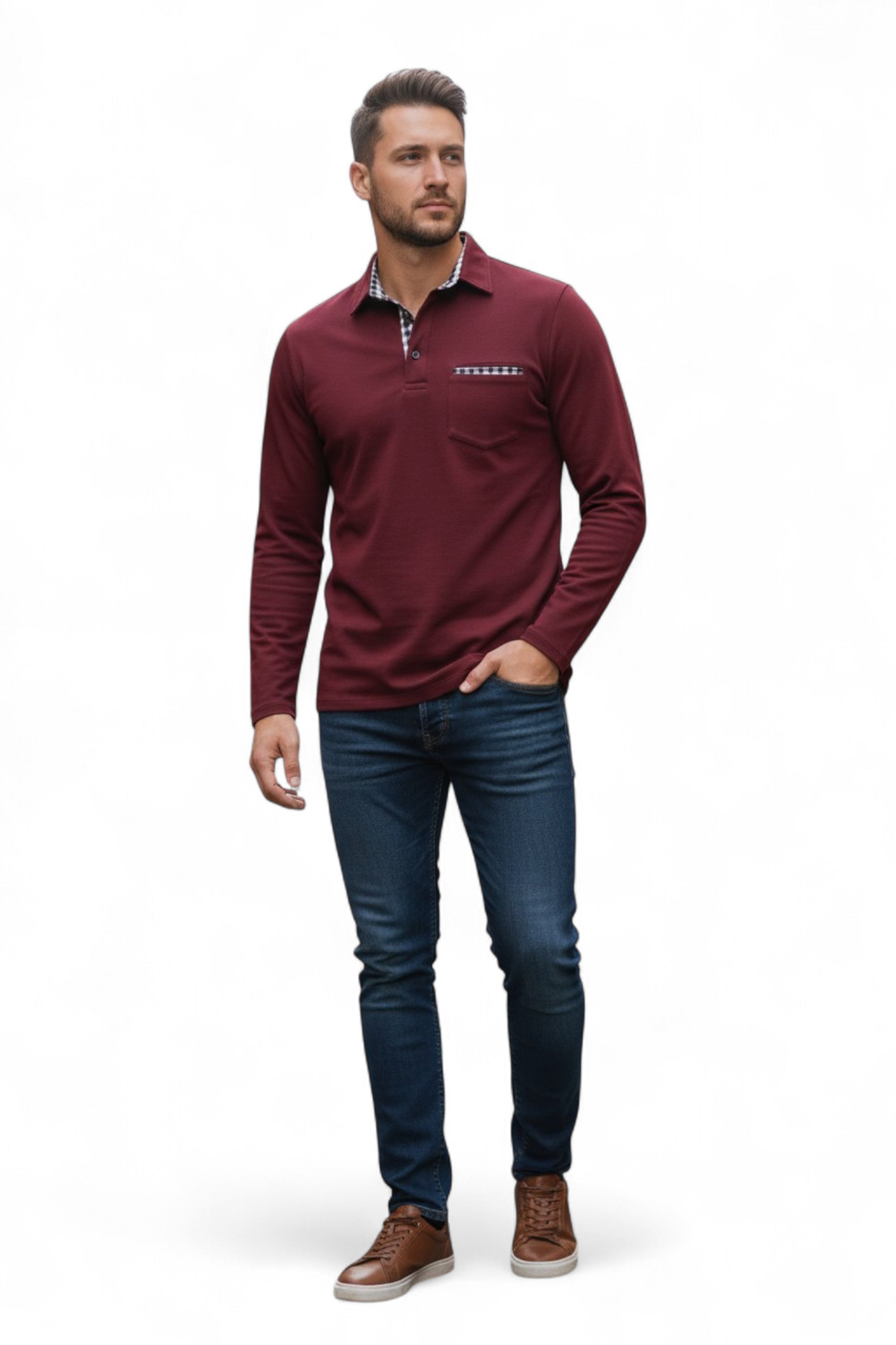 Man wearing a burgundy long-sleeve shirt with a logo, blue jeans, and brown shoes on a white background