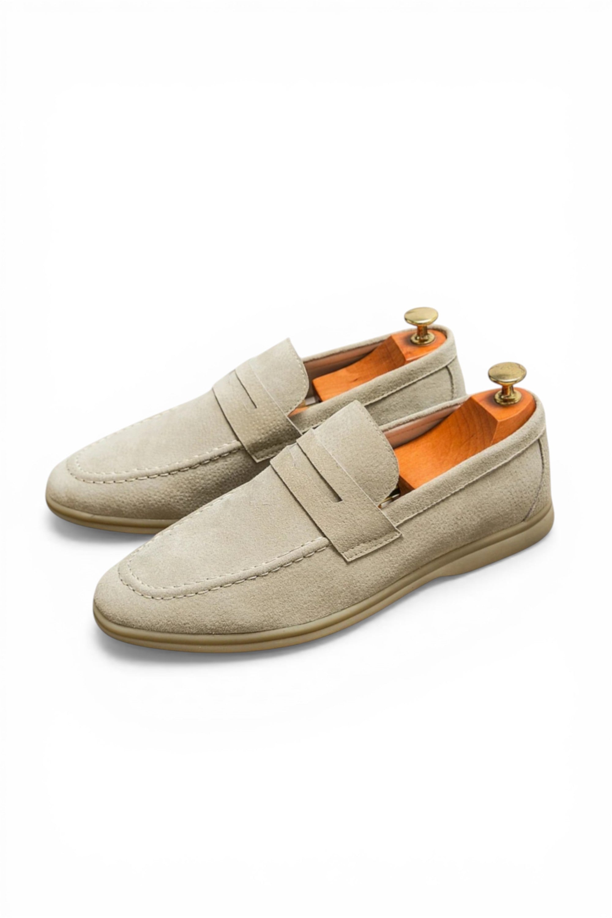 Beige loafers with orange lining on a white background