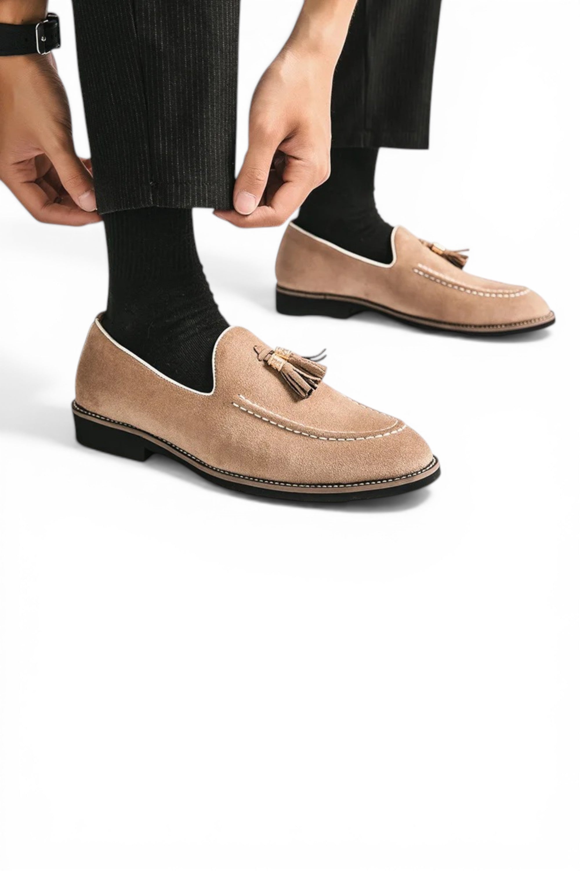 Beige loafers with tassels worn by a person on a white background