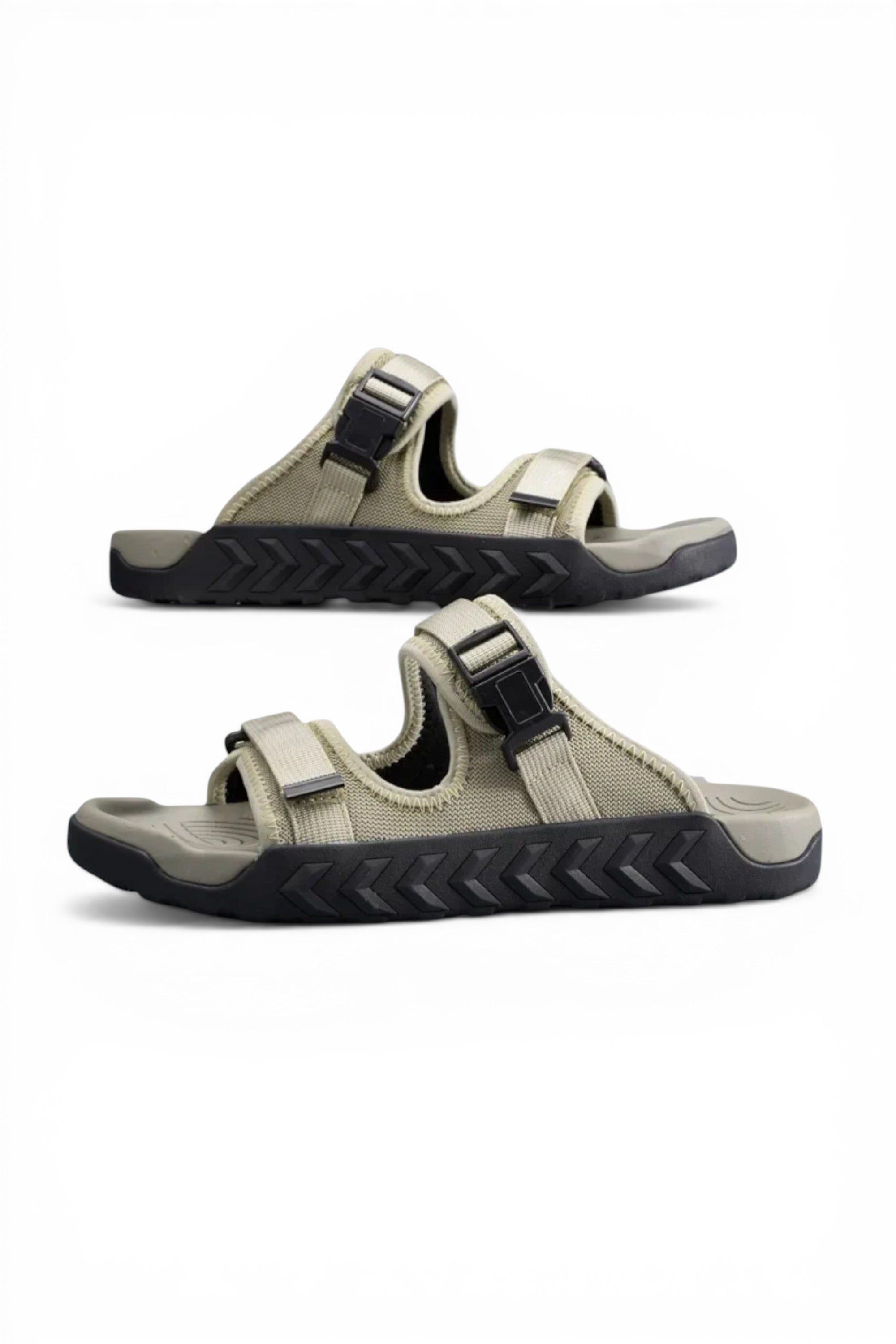 Pair of beige sandals with black soles on a white background