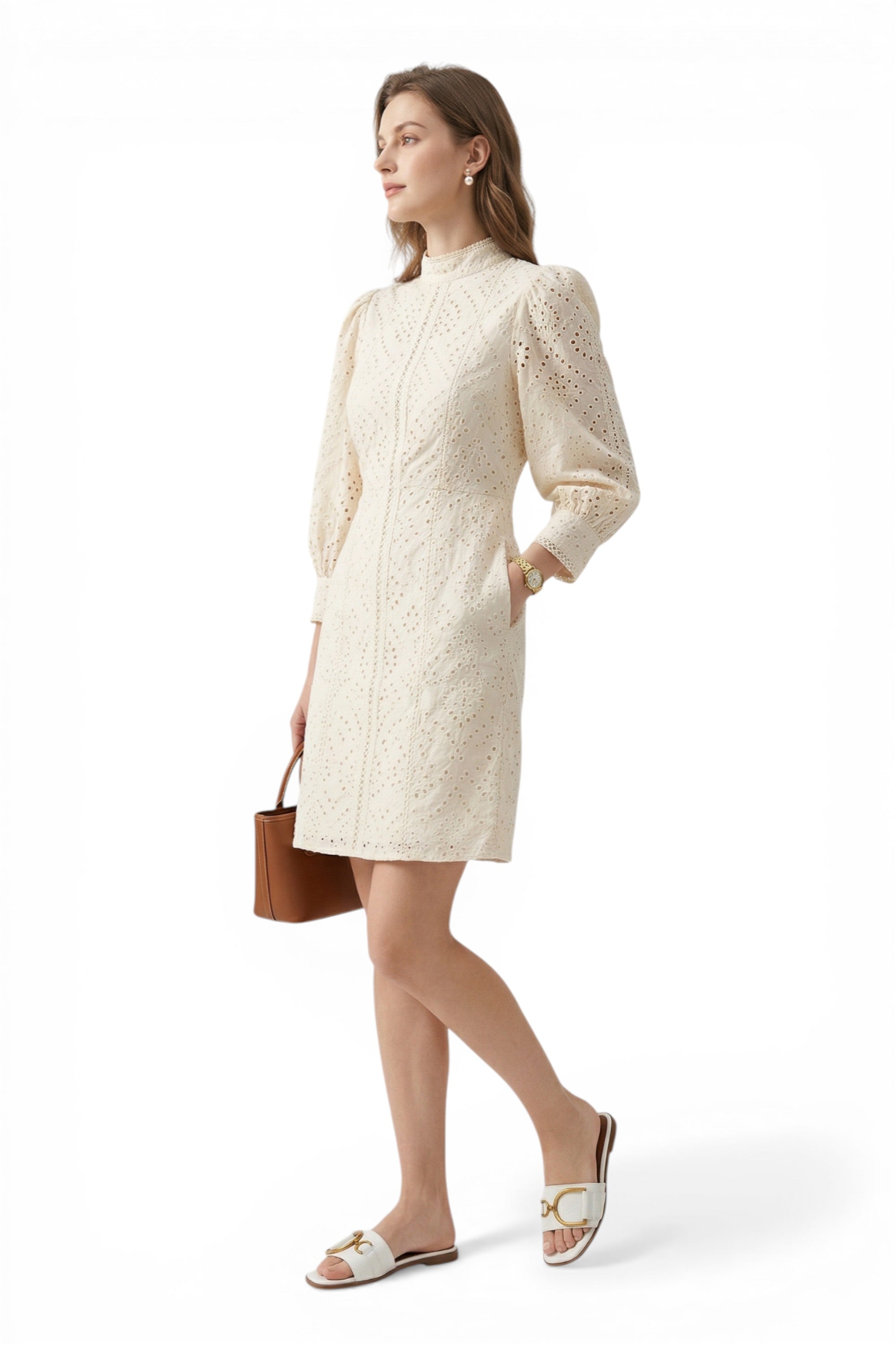 Woman wearing a white lace dress with a brown handbag on a white background