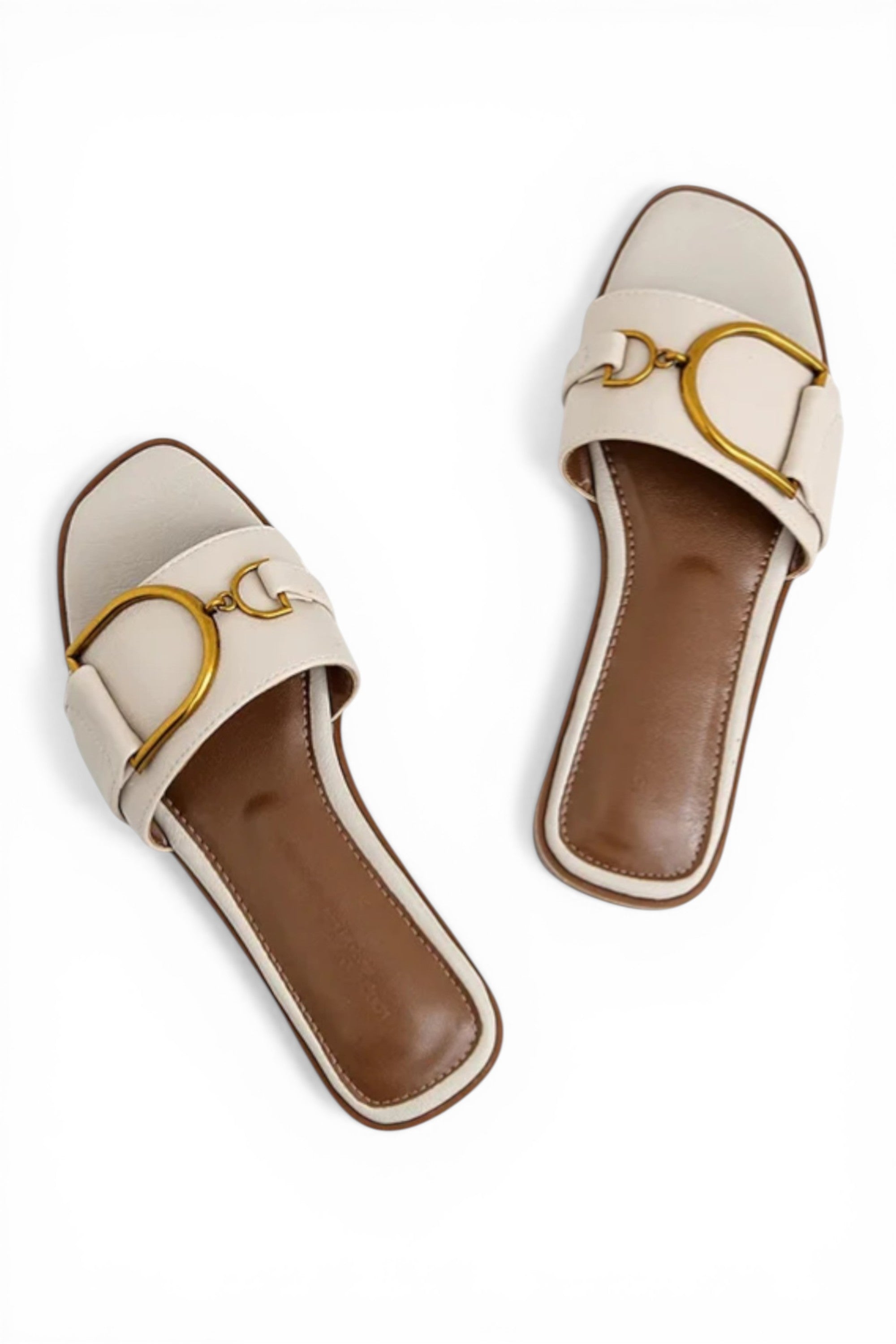 Pair of beige sandals with gold accents on a white background