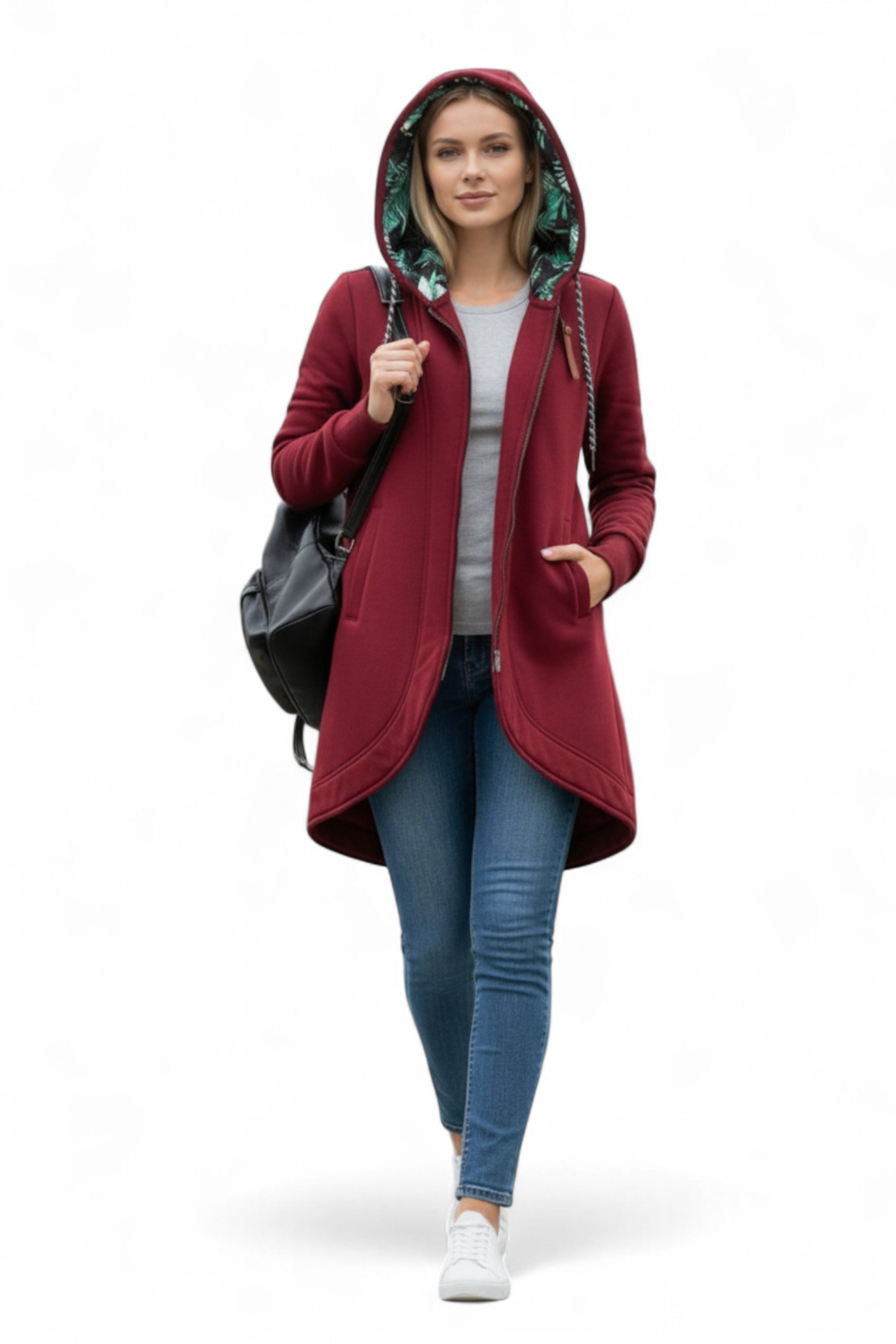 Woman wearing a red hooded coat with a plain white background