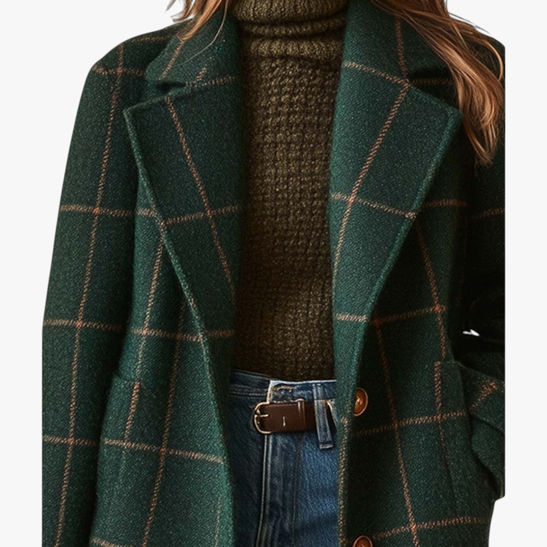 Green plaid coat worn over a brown sweater and blue jeans on a white background