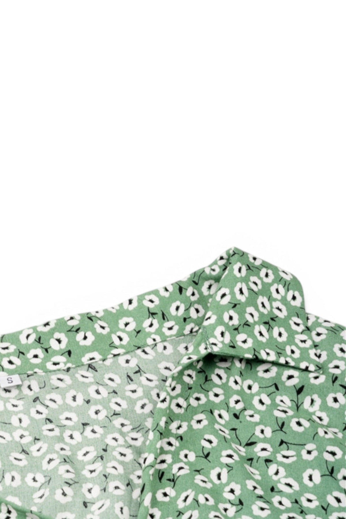 Green fabric with white floral pattern on a white background