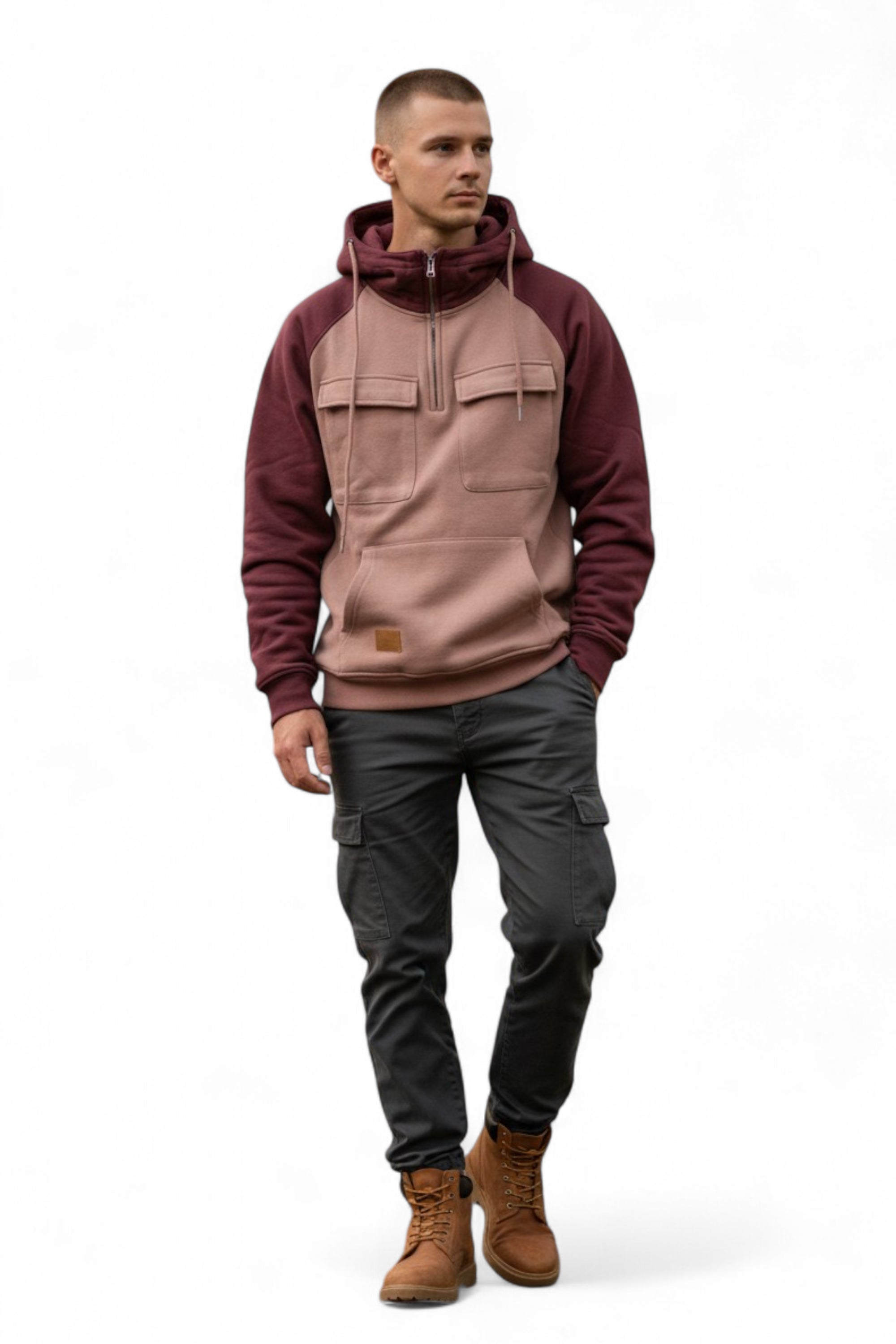 Man wearing a two-tone hoodie with maroon sleeves and a beige body, paired with dark pants and brown boots on a white background.
