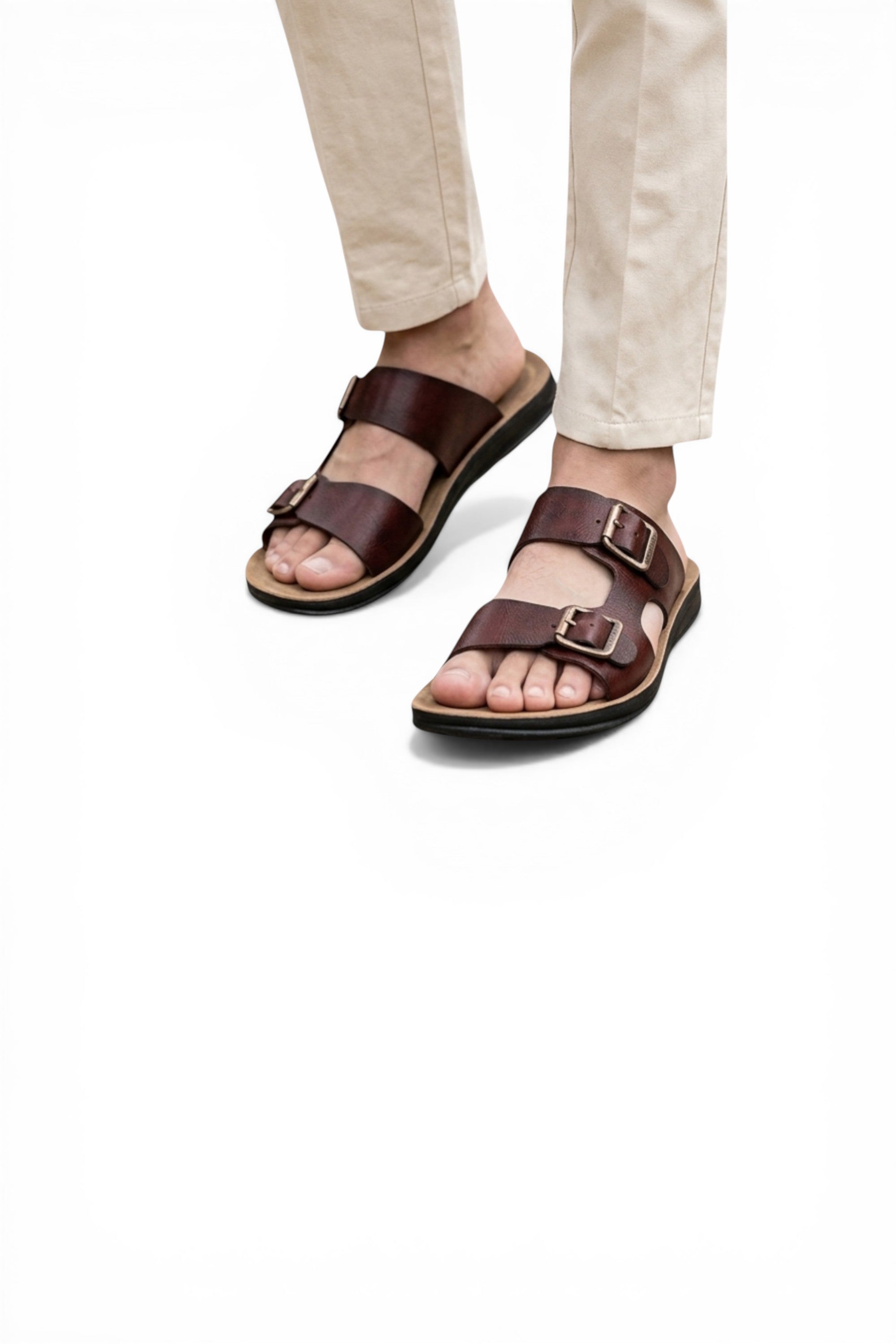 Brown sandals worn with light-colored pants on a white background