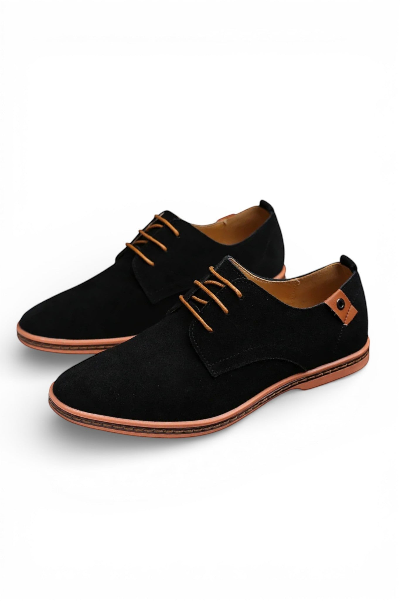 Black suede shoes with brown accents on a white background