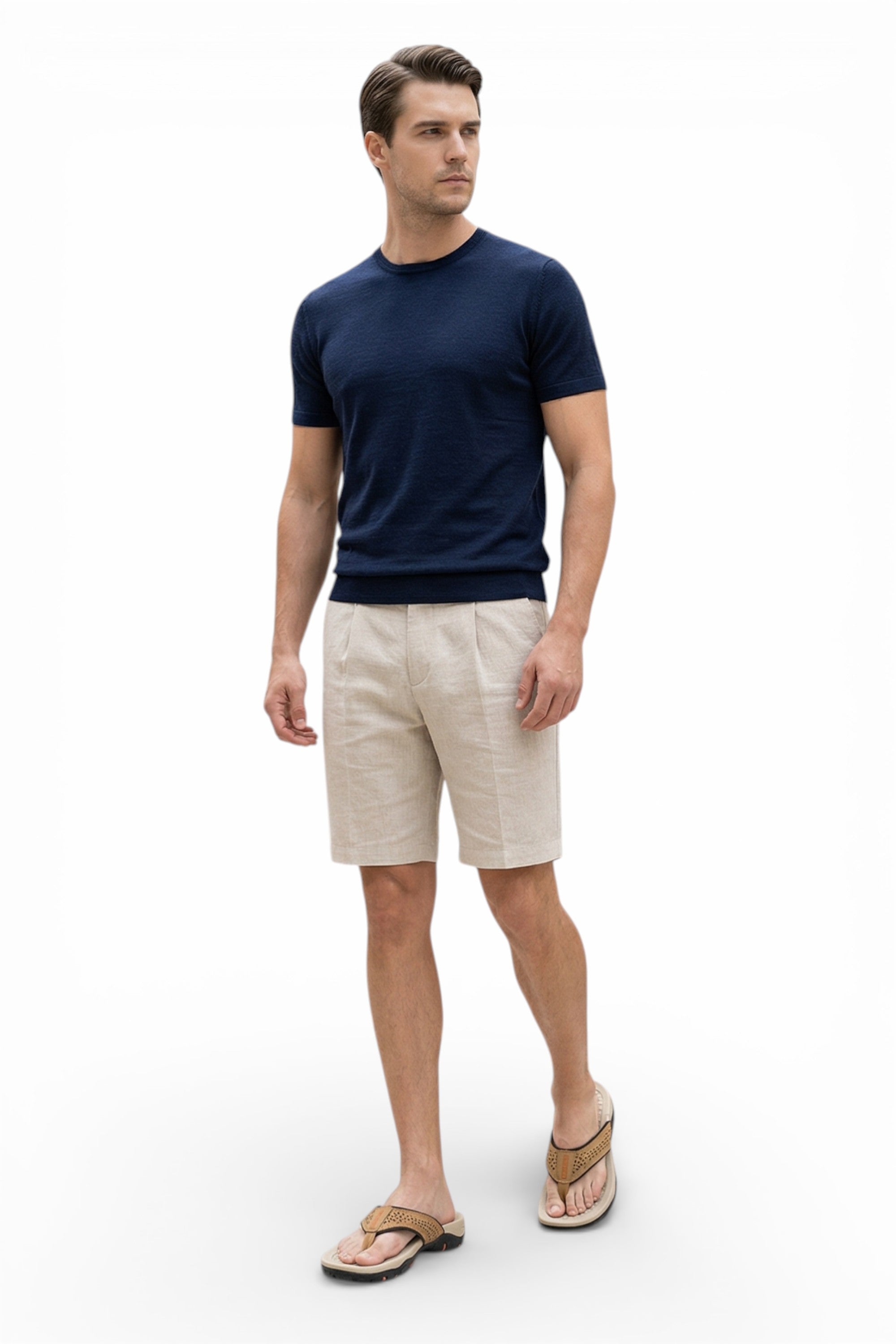 Man wearing a navy t-shirt and beige shorts on a white background