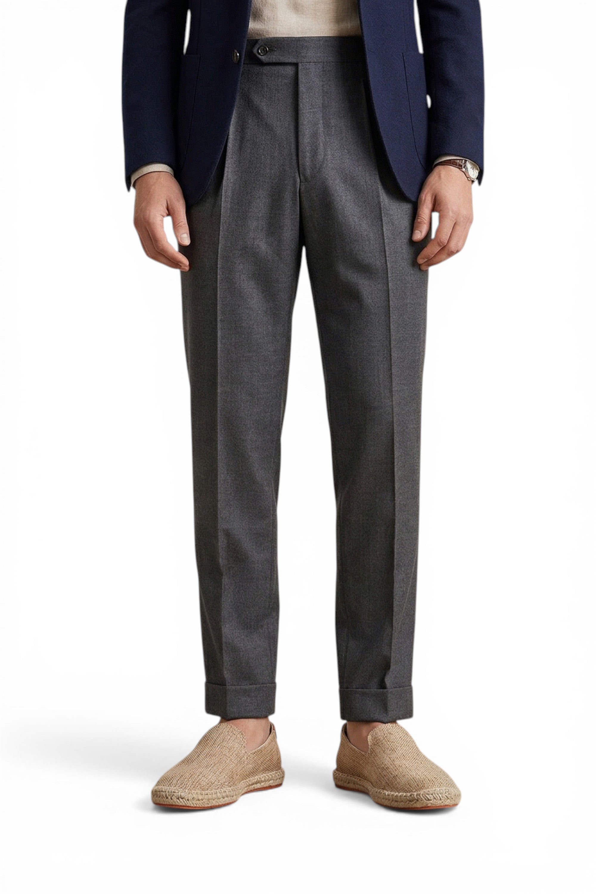 Person wearing a navy blazer, gray trousers, and beige shoes on a white background