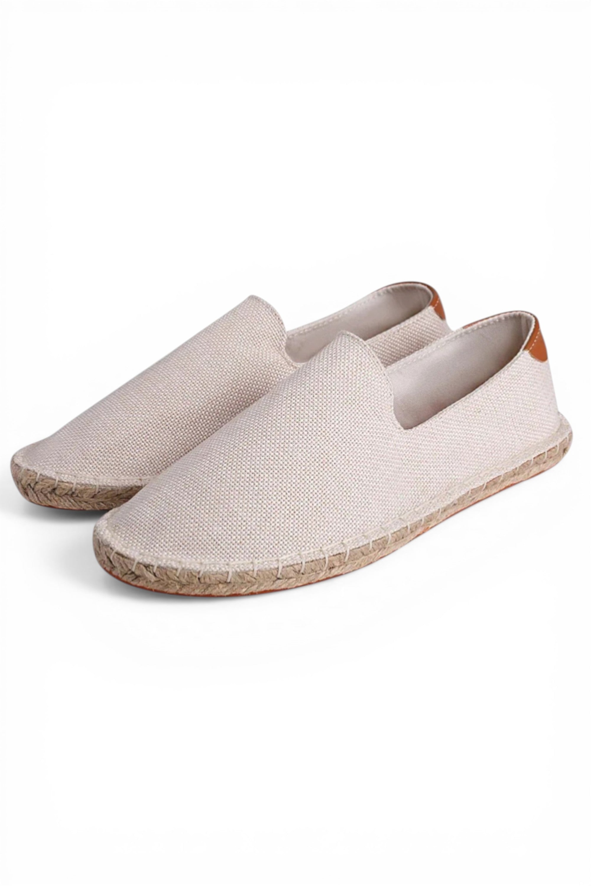 Pair of beige espadrilles on a white background