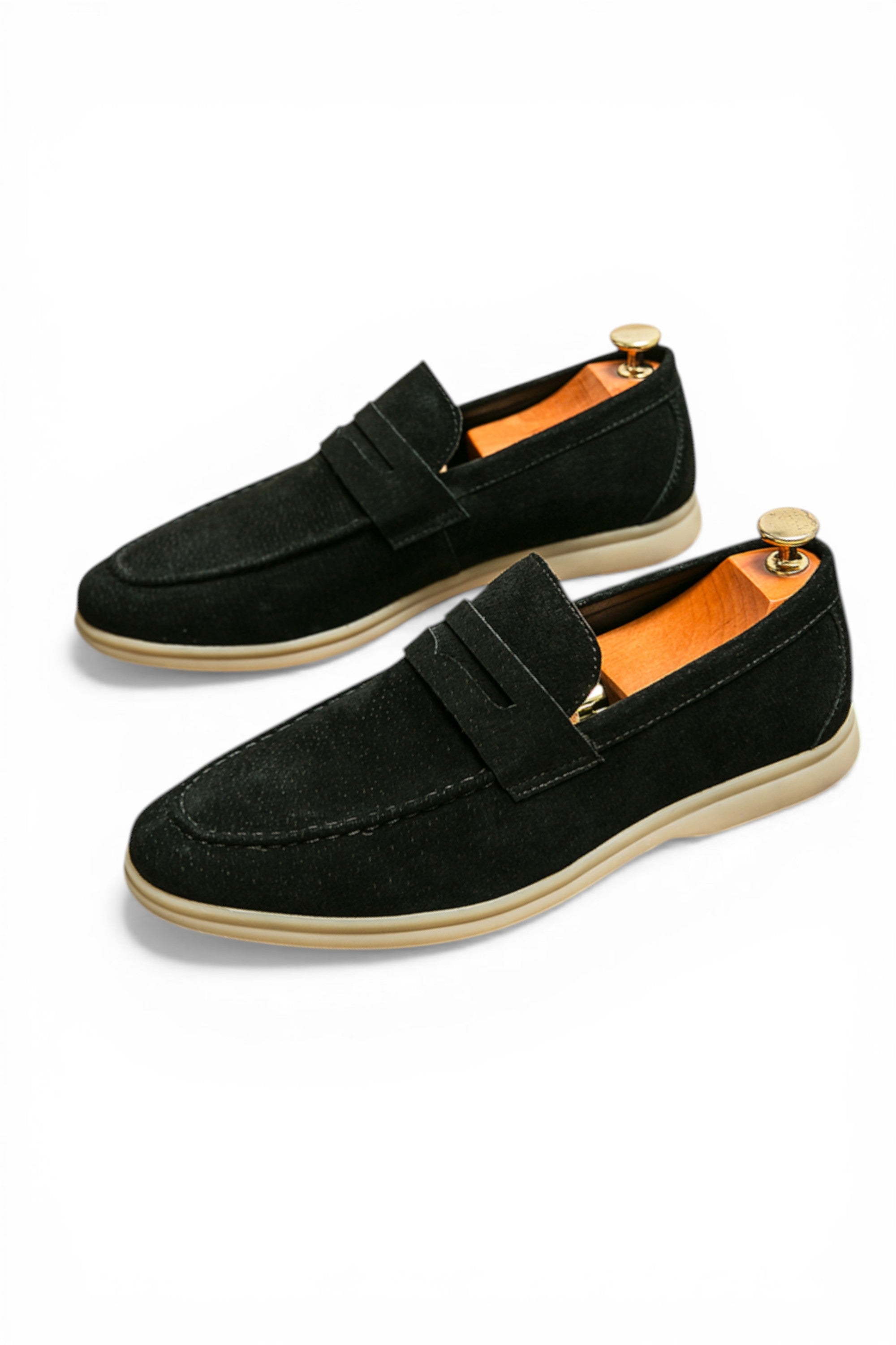 Pair of black loafers with gold accents on a white background