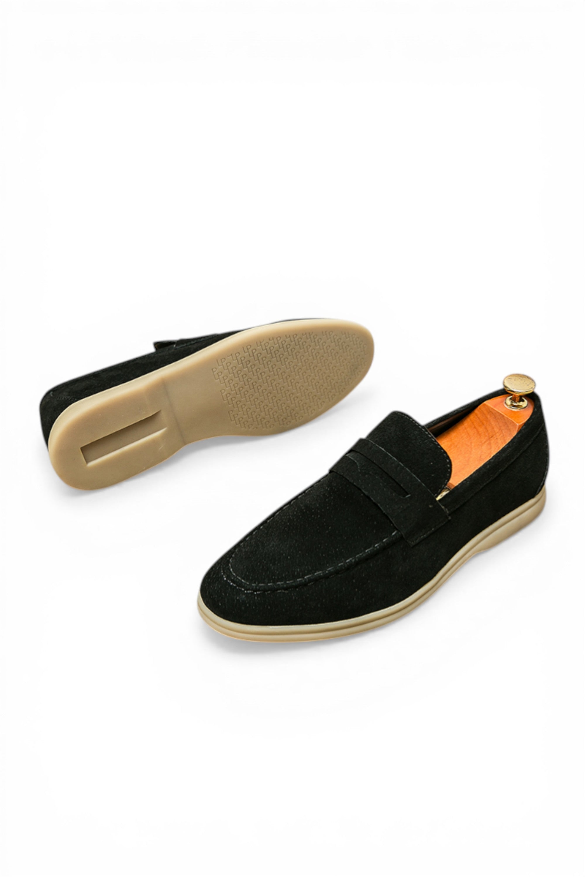 Black loafers with beige soles on a white background