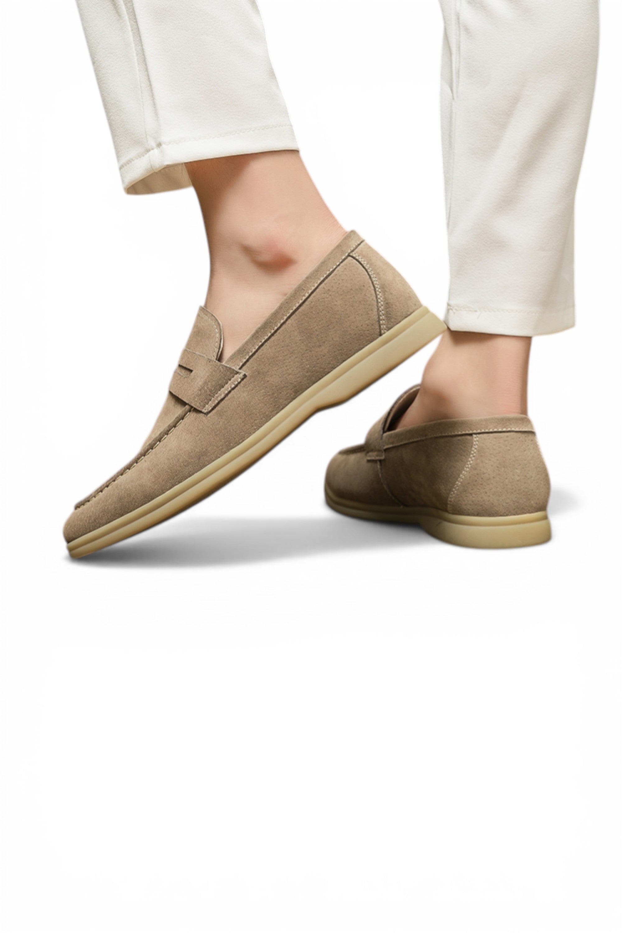 Beige loafers worn with white pants on a white background