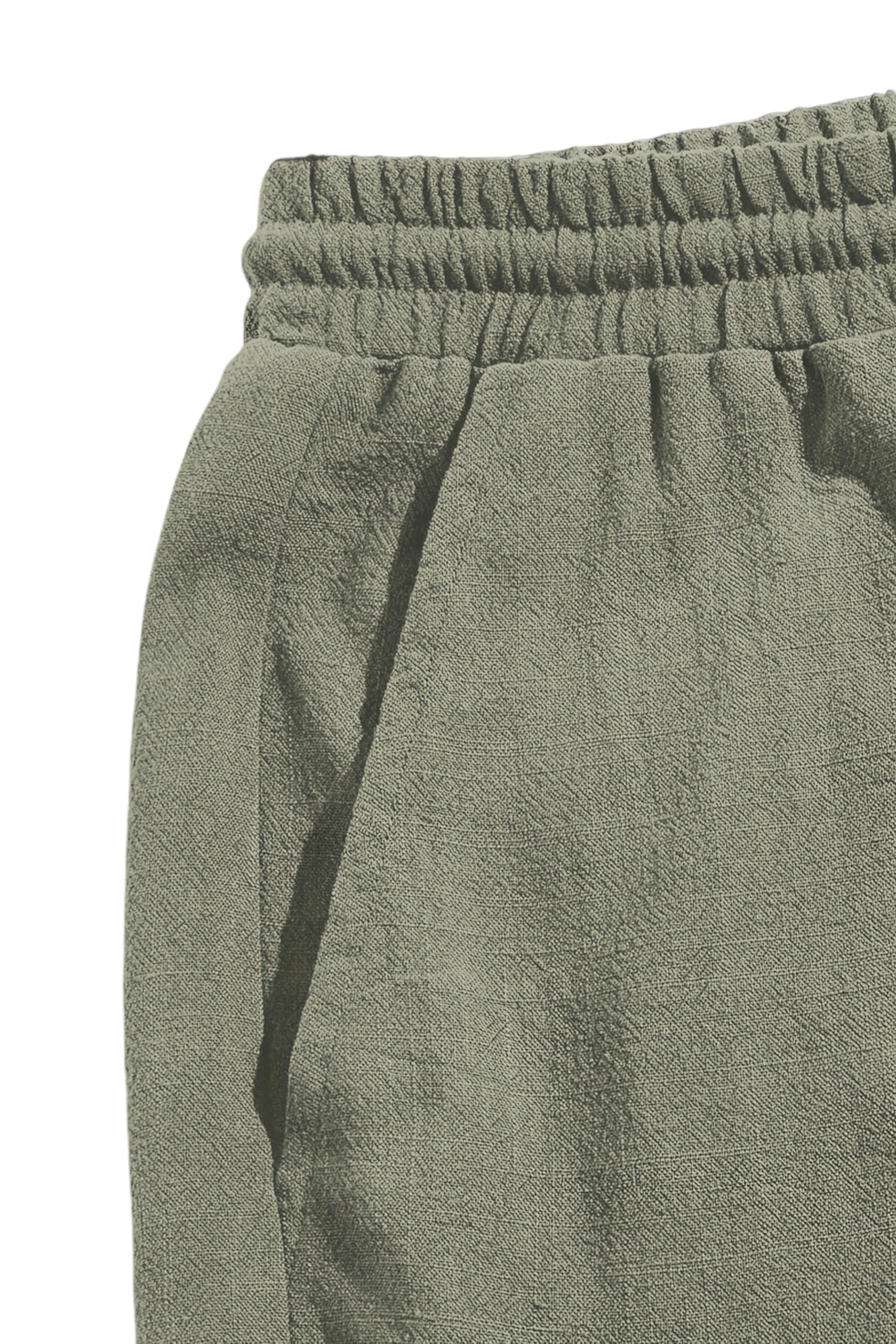 Close-up of green pants with an elastic waistband on a white background