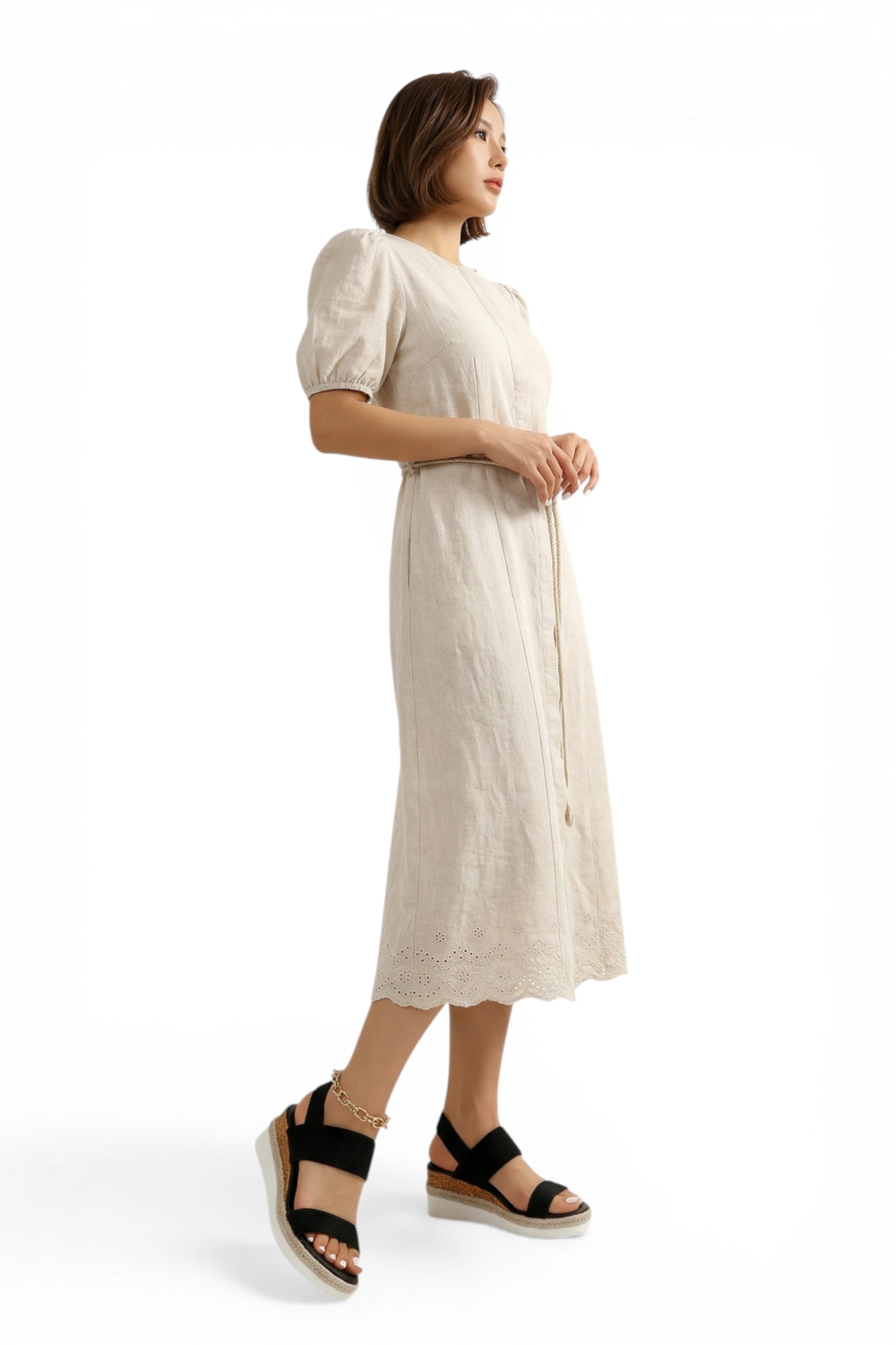 Woman wearing a beige dress on a white background