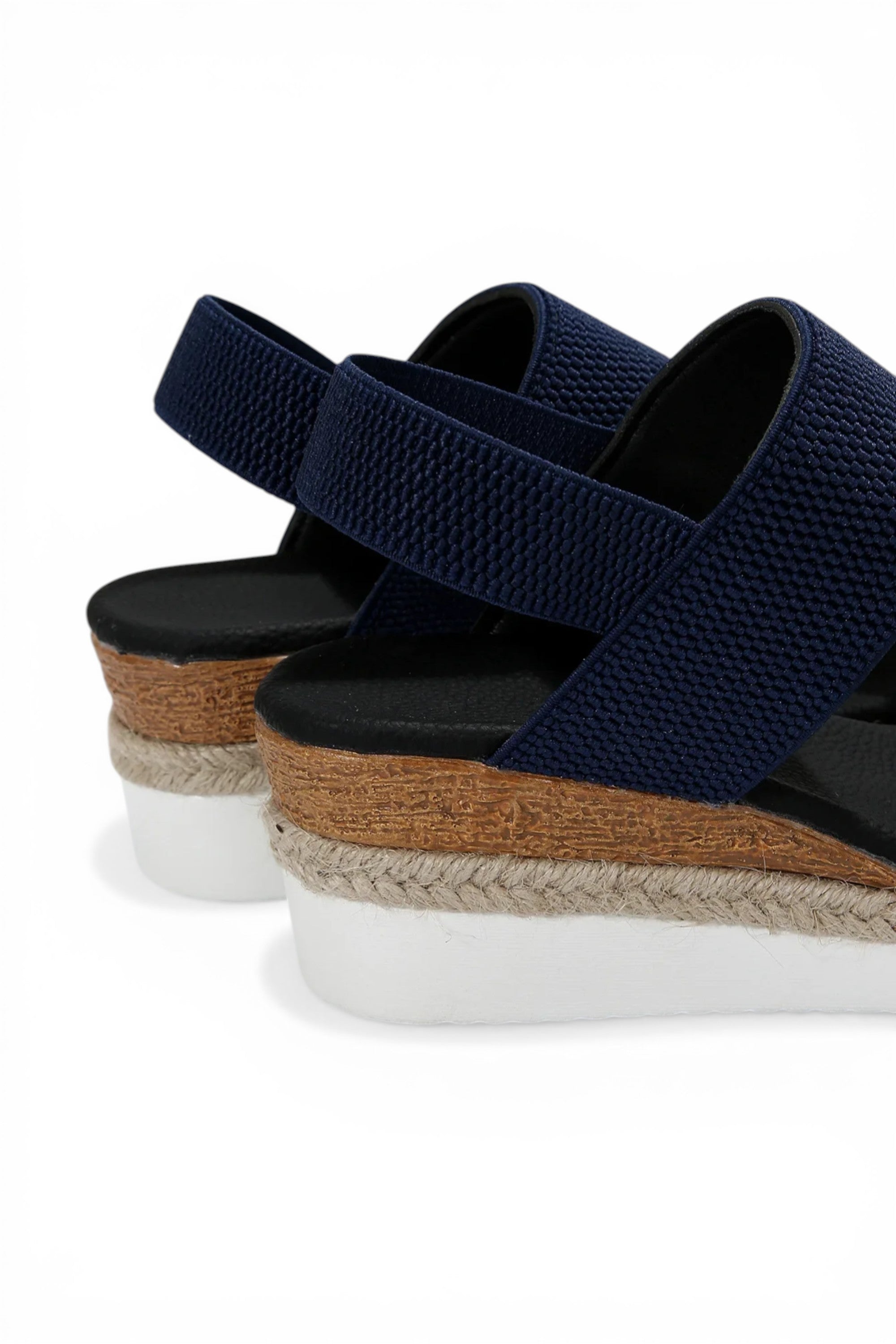 Navy wedge sandals with brown sole on a white background