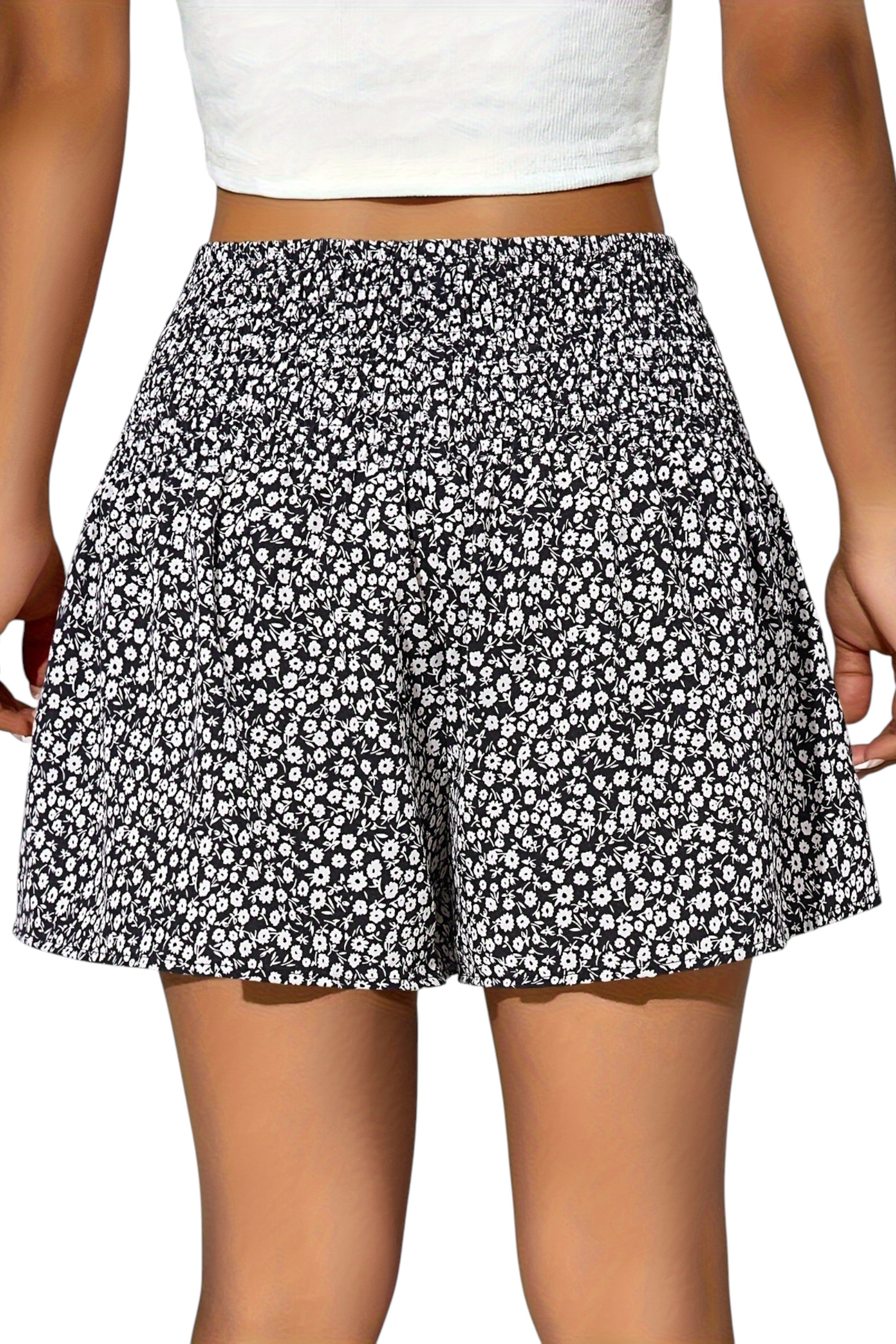Black and white floral shorts worn by a person on a plain background