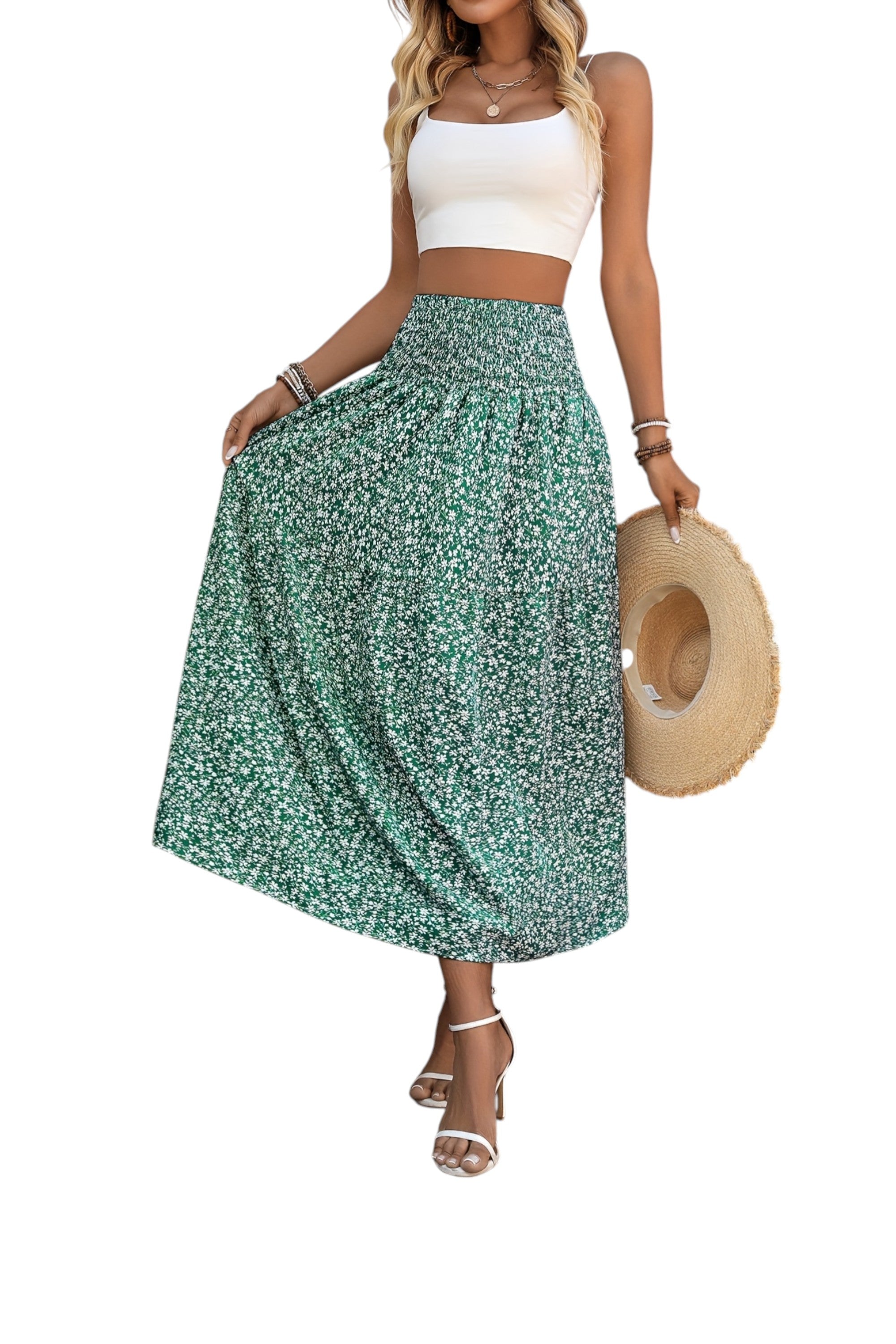 Woman wearing a green floral skirt and white top, holding a straw hat on a white background