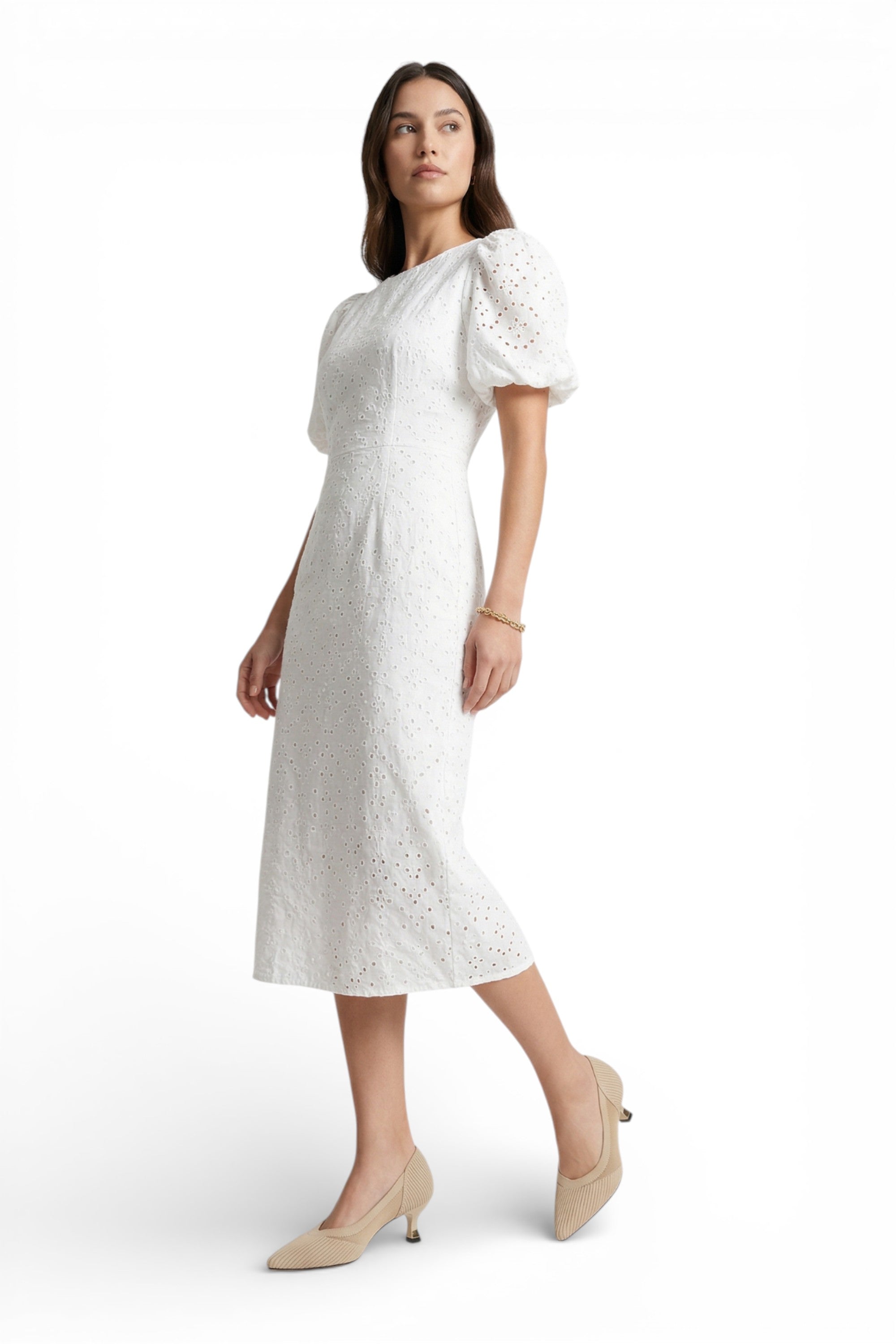 Woman wearing a white dress with puff sleeves on a white background