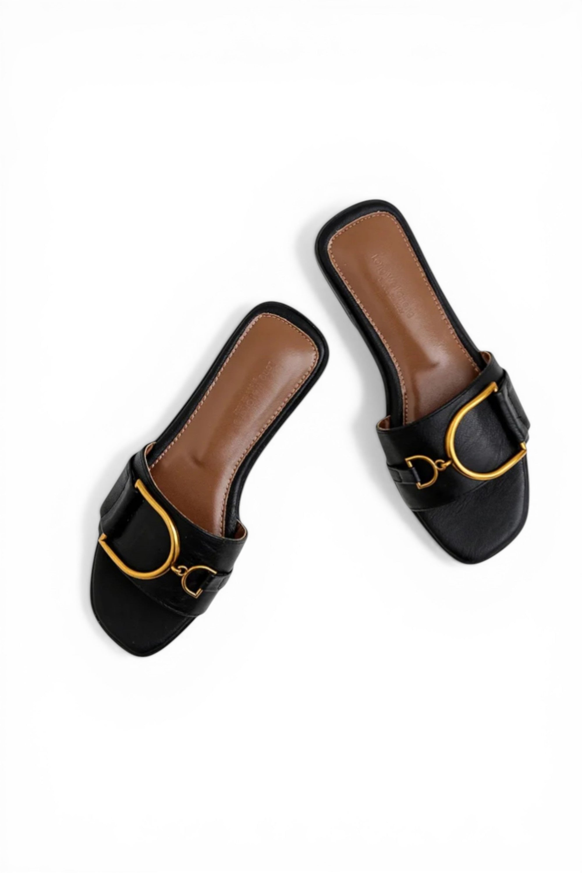 Black and brown slide sandals with gold accents on a white background