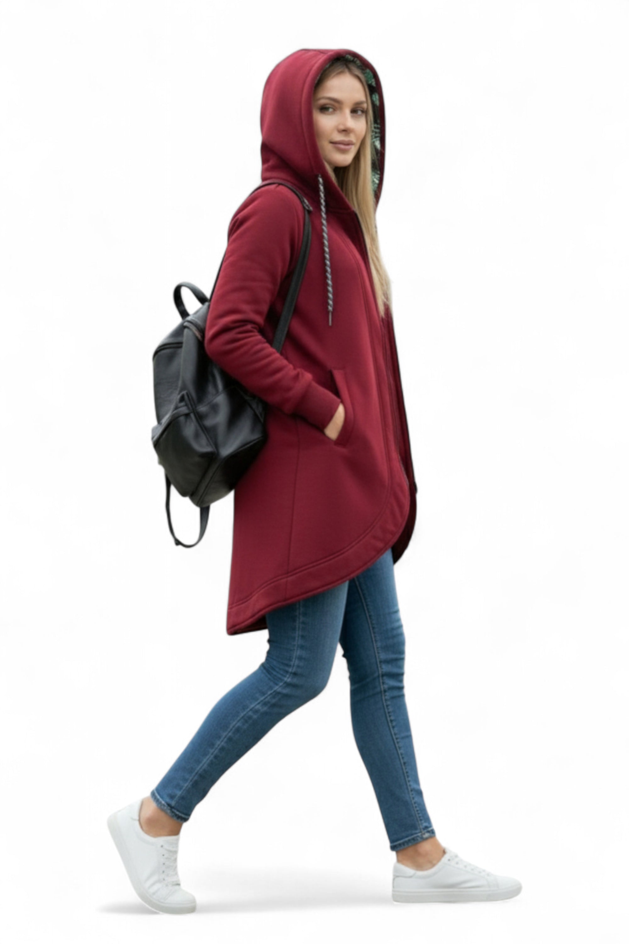 Person wearing a red hoodie, blue jeans, and white sneakers with a black backpack on a white background