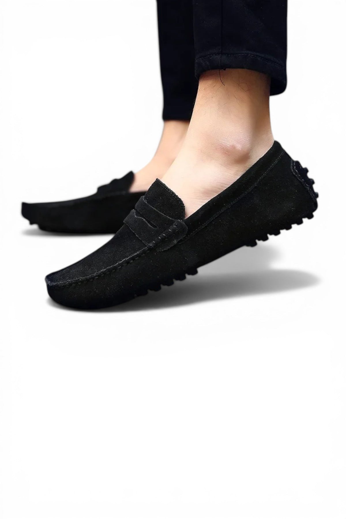 Black loafers worn with black pants on a white background