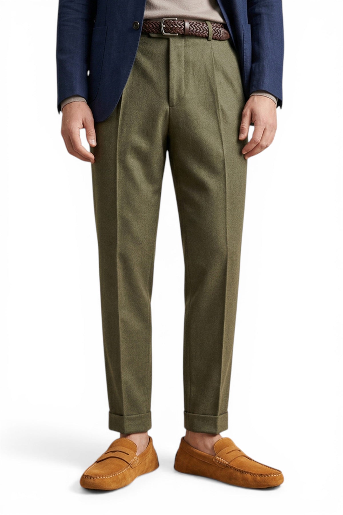 Person wearing olive green pants with a blue blazer and brown shoes on a white background